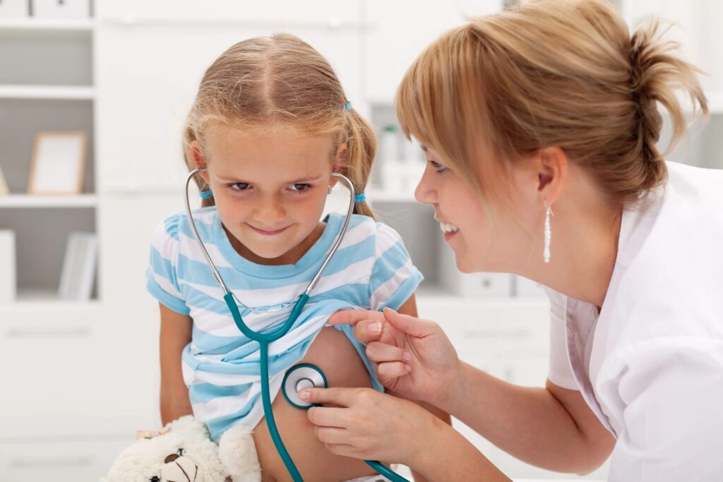 a pediatrician checking the heartbeat of a young patient